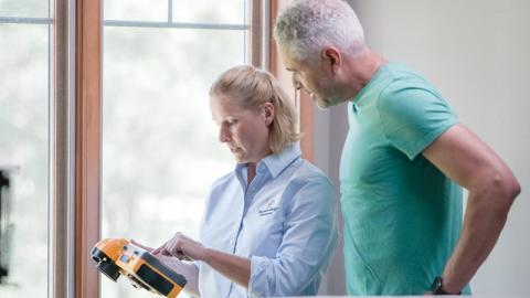 man and woman checking energy saving solution on ipad in home