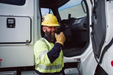 linemen standing by truck on microphone