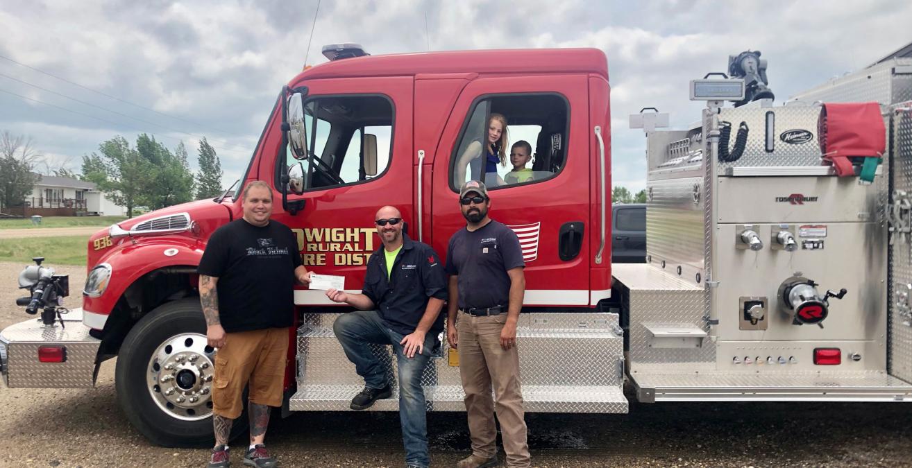dvec line foreman josh hoffman and lineworker nick-mauer giving dwight fire chief andy gregor
